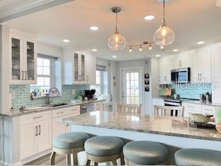 4650 Links Village Drive, Unit B503 Ponce Inlet, FL 32127 - Photo 13 of 47 a kitchen with kitchen island stainless steel appliances a dining table chairs sink and stove