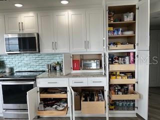 4650 Links Village Drive, Unit B503 Ponce Inlet, FL 32127 - Photo 17 of 47 a kitchen with stainless steel appliances granite countertop a stove and cabinets