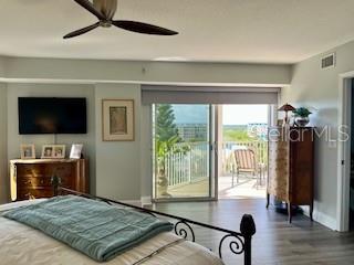 4650 Links Village Drive, Unit B503 Ponce Inlet, FL 32127 - Photo 23 of 47 a bedroom with a bed and a flat screen tv