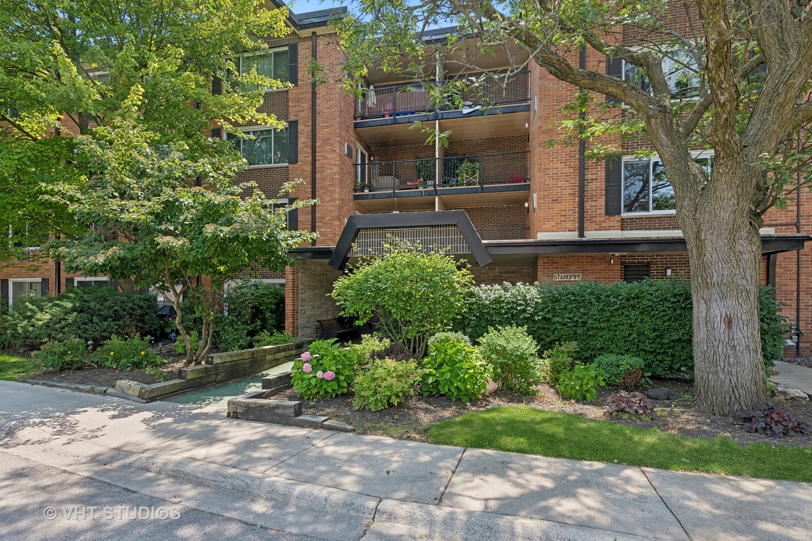 1107 South Old Wilke Road, Unit 205 Rolling Meadows, IL 60008 - Photo 1 of 19 a front view of a house with garden