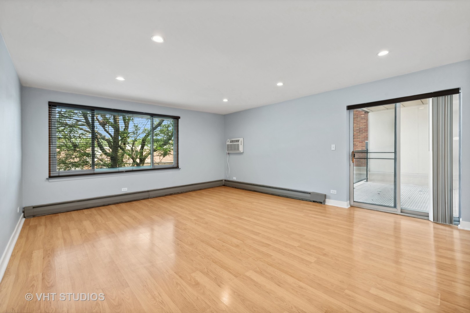 1107 South Old Wilke Road, Unit 205 Rolling Meadows, IL 60008 - Photo 7 of 19 a view of an empty room with wooden floor and a window