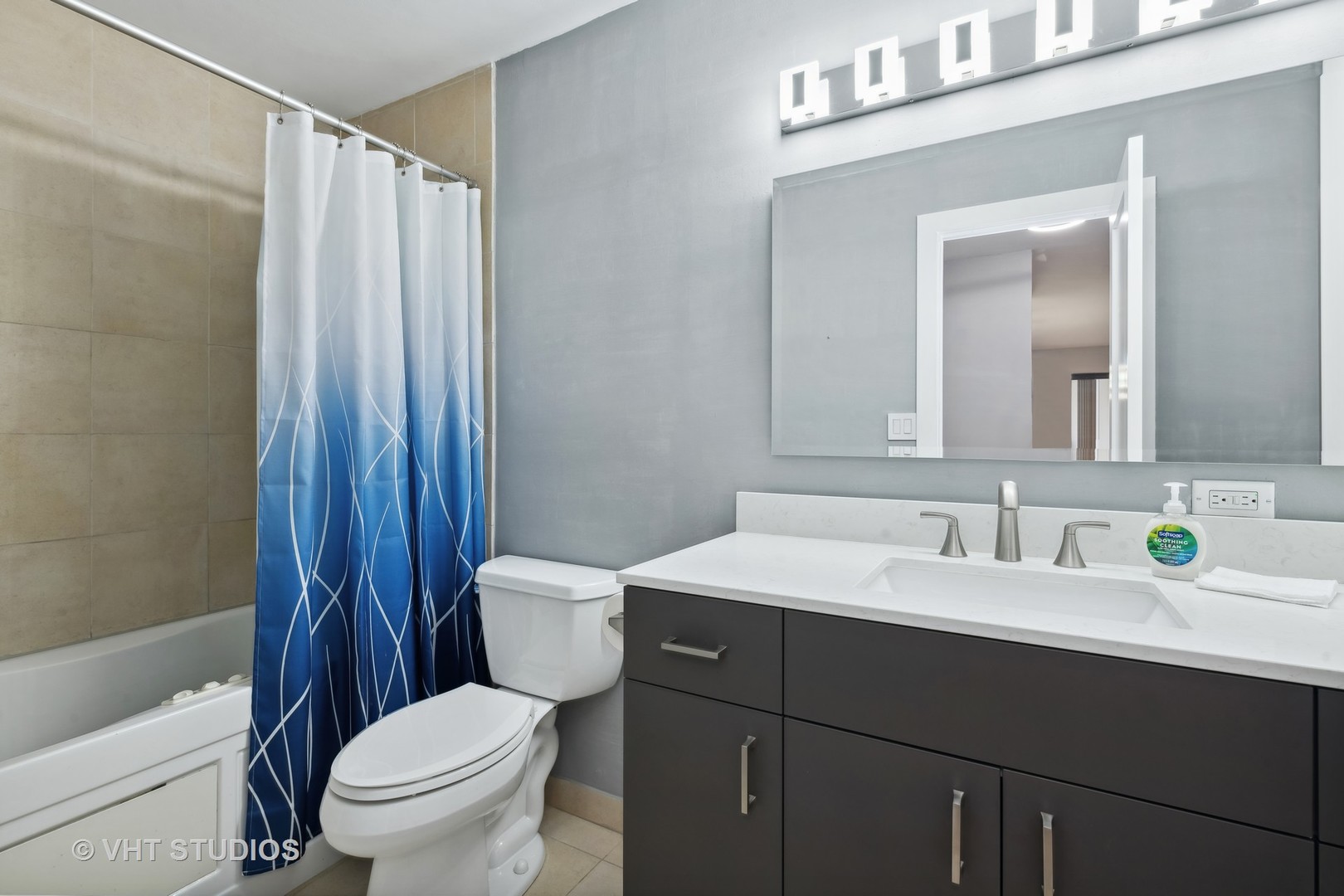 1107 South Old Wilke Road, Unit 205 Rolling Meadows, IL 60008 - Photo 10 of 19 a bathroom with a sink a toilet a mirror and shower