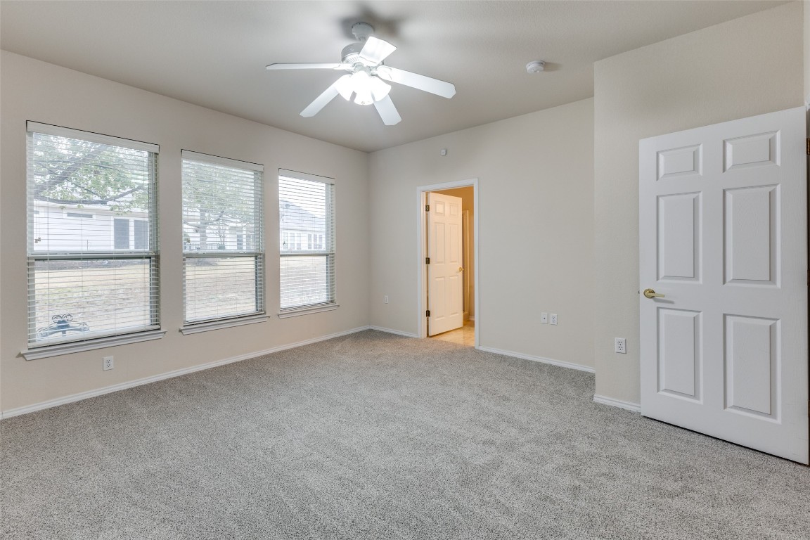 206 Bonham Loop Georgetown, TX 78633 - Photo 8 of 18 an empty room with chandelier fan and windows