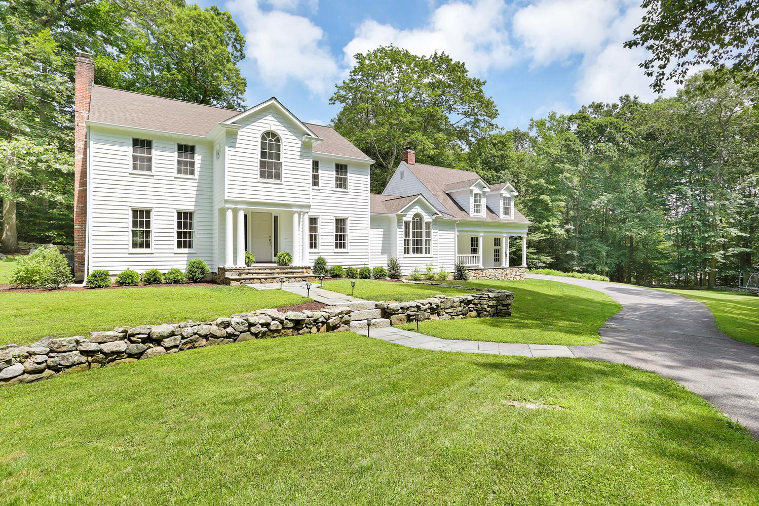 171 Jonathan Road New Canaan, CT 06840 - Photo 1 of 38 a front view of a house with a garden and trees