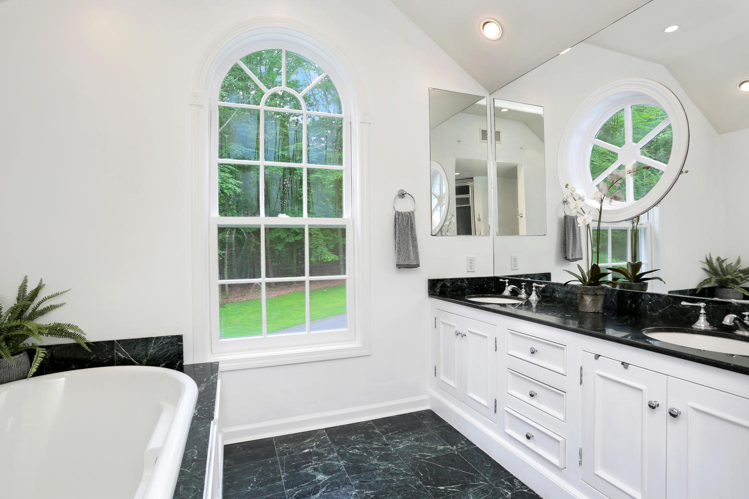 171 Jonathan Road New Canaan, CT 06840 - Photo 24 of 38 a bathroom with a granite countertop sink a large mirror and a bathtub next to a window