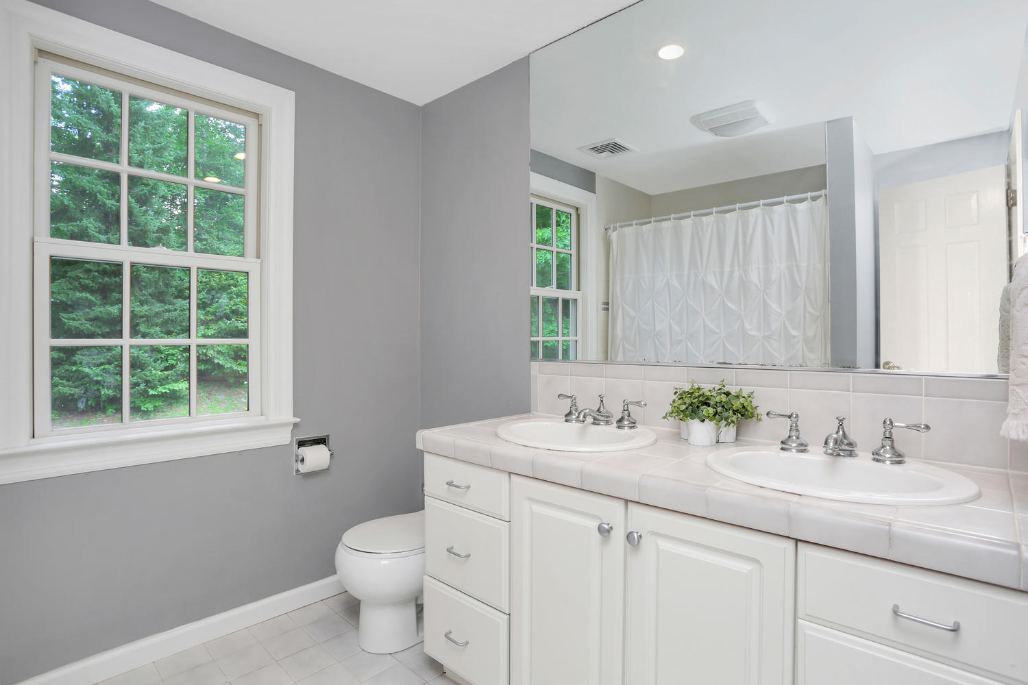 171 Jonathan Road New Canaan, CT 06840 - Photo 28 of 38 a bathroom with a granite countertop toilet a sink a mirror and a window