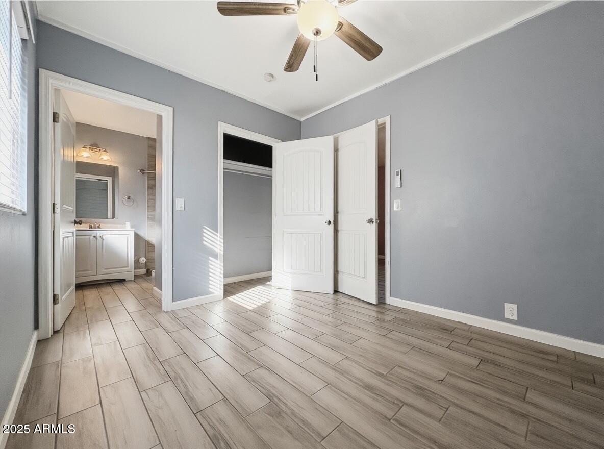513 East Hatcher Road, Unit 3 Phoenix, AZ 85020 - Photo 6 of 9 a view of a room with wooden floor a ceiling fan and windows