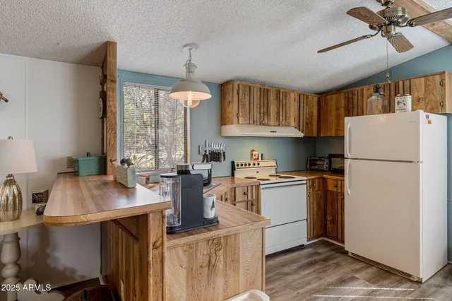 a kitchen with refrigerator cabinets and wooden floor