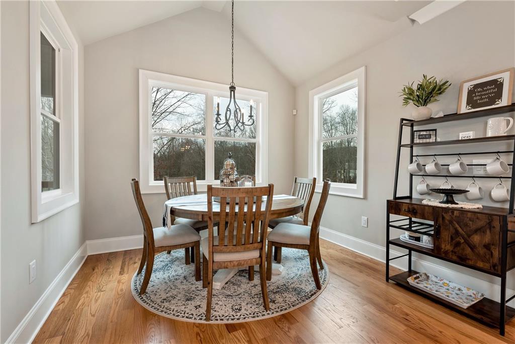 6140 Crescent Moon Ridge Cumming, GA 30041 - Photo 11 of 54 a dining room with furniture a chandelier and wooden floor