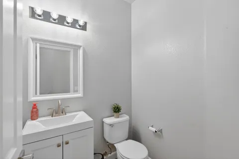 a bathroom with a toilet a sink and mirror