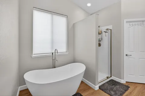 a bathroom with a white tub shower and sink