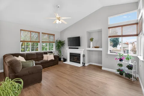 a living room with furniture a flat screen tv and a fireplace