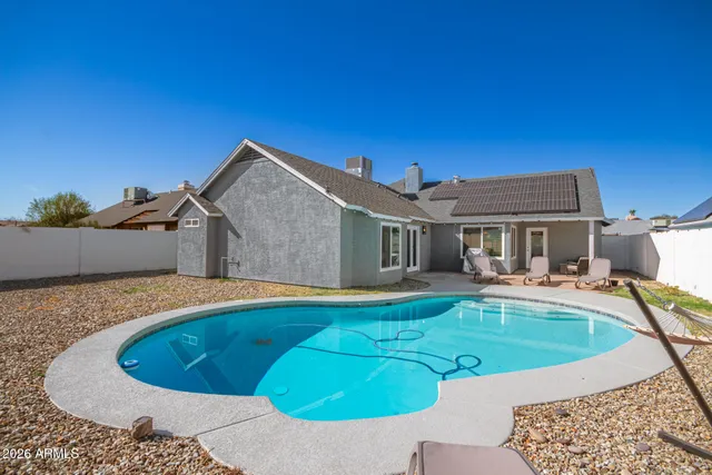 a view of a house with swimming pool and sitting area