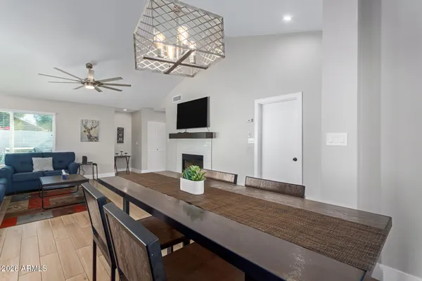 a view of a dining room with furniture a chandelier and wooden floor