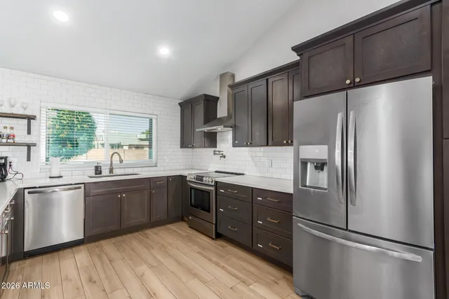 a kitchen with stainless steel appliances granite countertop a refrigerator and a sink