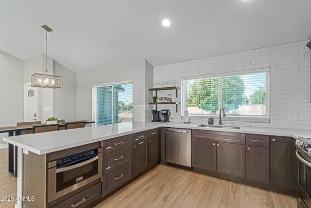 a kitchen with a sink stove and wooden floor