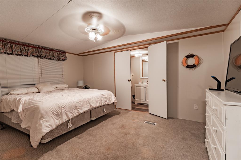 4705 Fox Hollow Road, Unit 30 Graham, TX 76450 - Photo 11 of 31 a spacious bedroom with a bed and a chandelier
