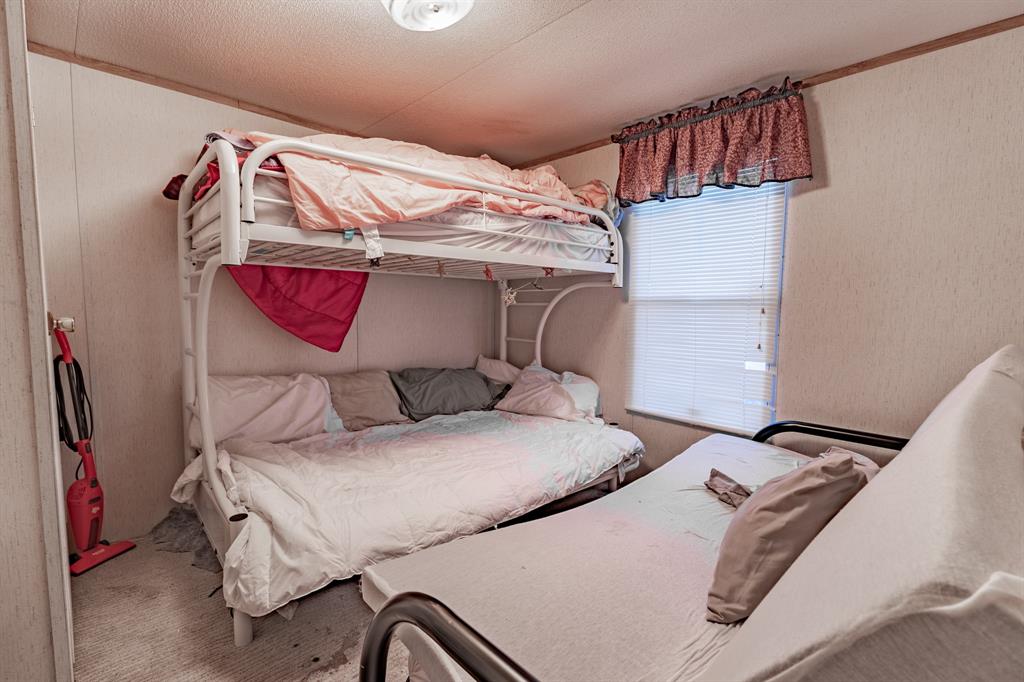 4705 Fox Hollow Road, Unit 30 Graham, TX 76450 - Photo 14 of 31 a bed sitting in a bedroom next to a lamp