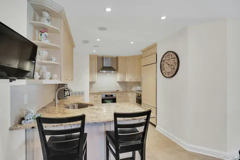 a kitchen with kitchen island a sink a stove and chairs