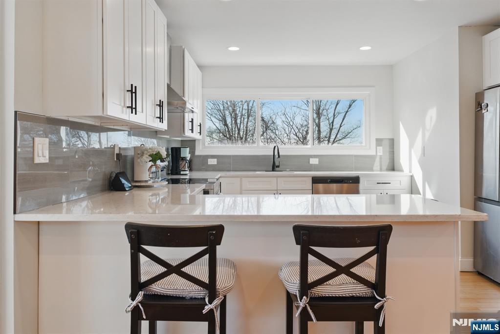 21 Skyview Road Ringwood, NJ 07456 - Photo 28 of 49 a kitchen with stainless steel appliances a table and chairs in it