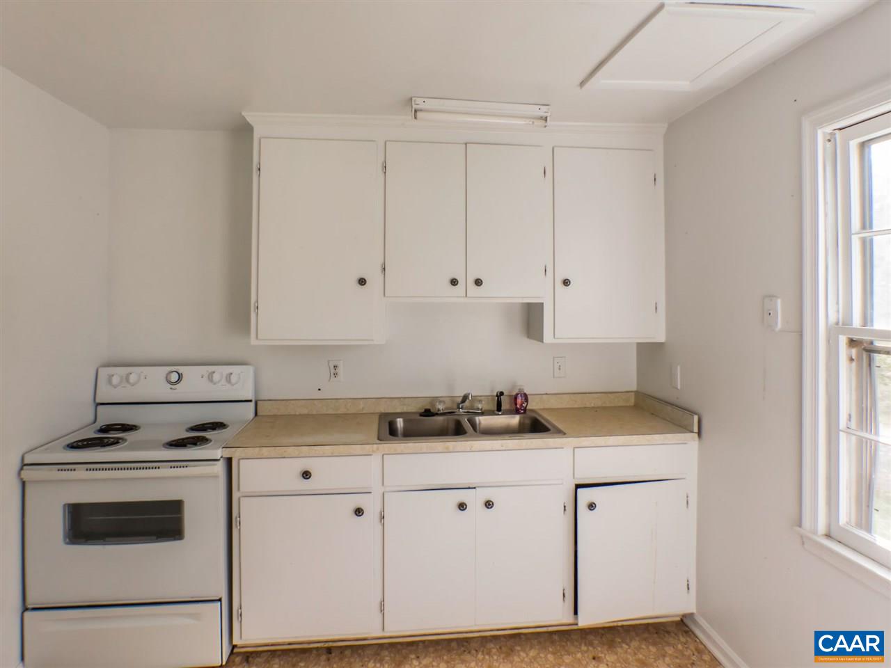 7595 Esmont Road Esmont, VA 22937 - Photo 8 of 30 a kitchen with granite countertop white cabinets and white appliances