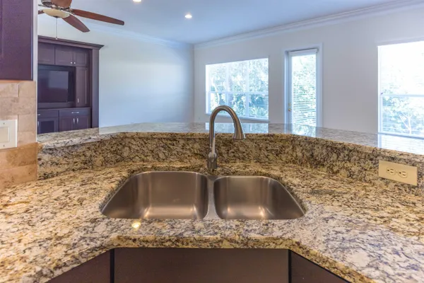 a large kitchen with granite countertop a stove and a sink