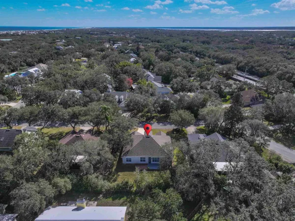 an aerial view of residential houses with outdoor space and trees