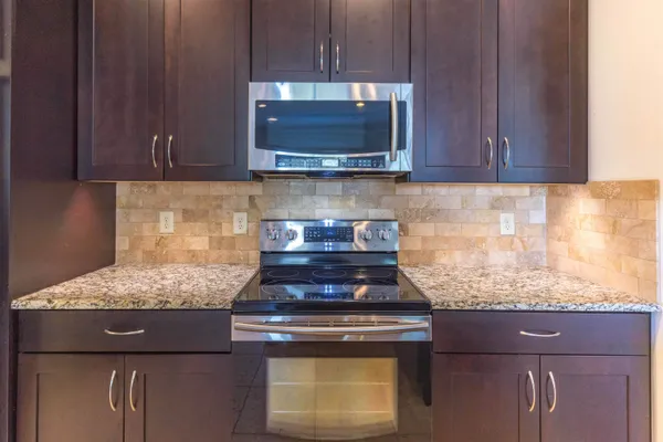 a kitchen with stainless steel appliances granite countertop a refrigerator and a sink