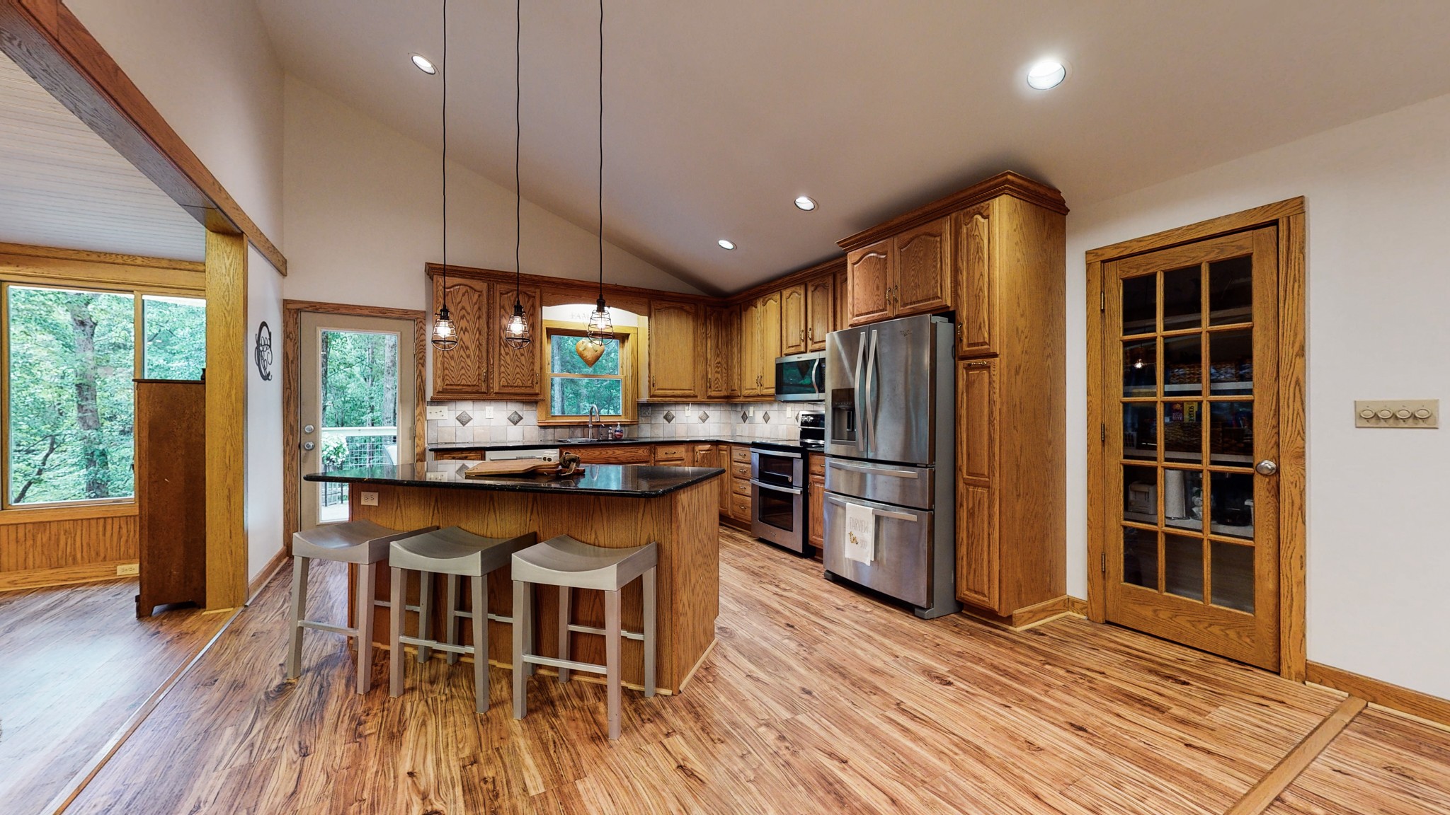 7449 Les Hughes Road Fairview, TN 37062 - Photo 11 of 49 a kitchen with stainless steel appliances granite countertop a refrigerator a oven a sink a dining table and chairs with wooden floor