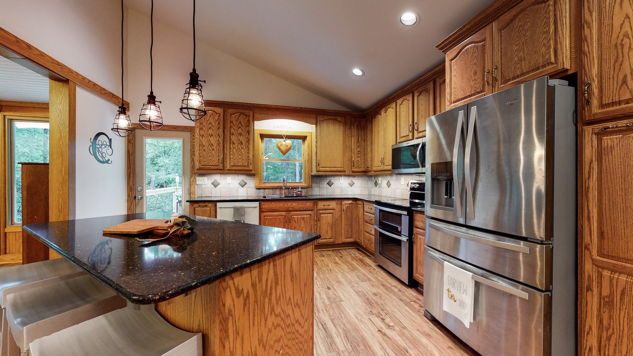 7449 Les Hughes Road Fairview, TN 37062 - Photo 12 of 49 a kitchen with stainless steel appliances granite countertop a refrigerator a sink dishwasher a stove and white countertops with wooden floor