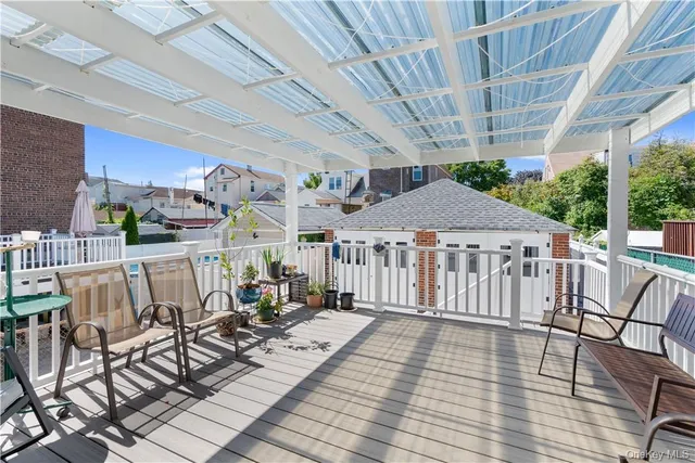 a view of a patio with table and chairs with wooden floor and fence