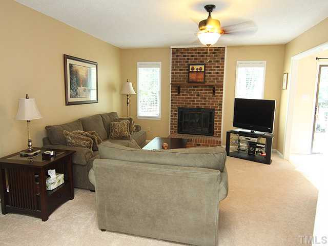 5705 Lake Elton Road Durham, NC 27713 - Photo 2 of 12 The living room boasts a masonry wood burning fireplace with raised hearth and a ceiling fan. Living Room