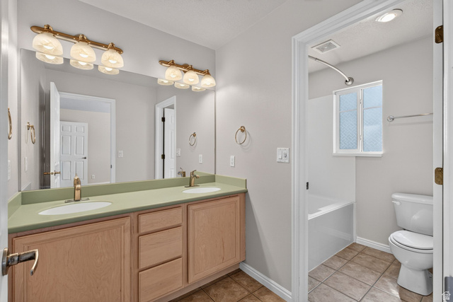 1305 Alpine Way Provo, UT 84606 - Photo 32 of 56 Dual vanity with light wood-finish cabinetry, a single basin tub, and tile flooring
