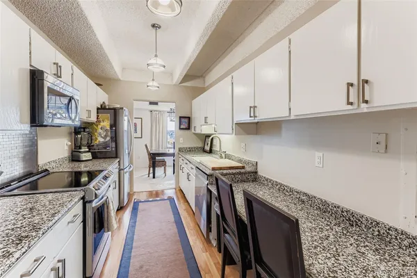 a kitchen with stainless steel appliances granite countertop a sink refrigerator and cabinets