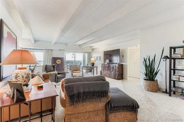 a living room with furniture a flat screen tv and a window