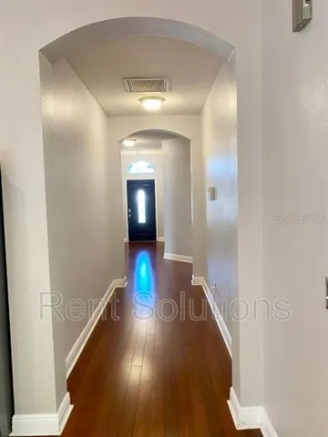 a view of a hallway with wooden floor