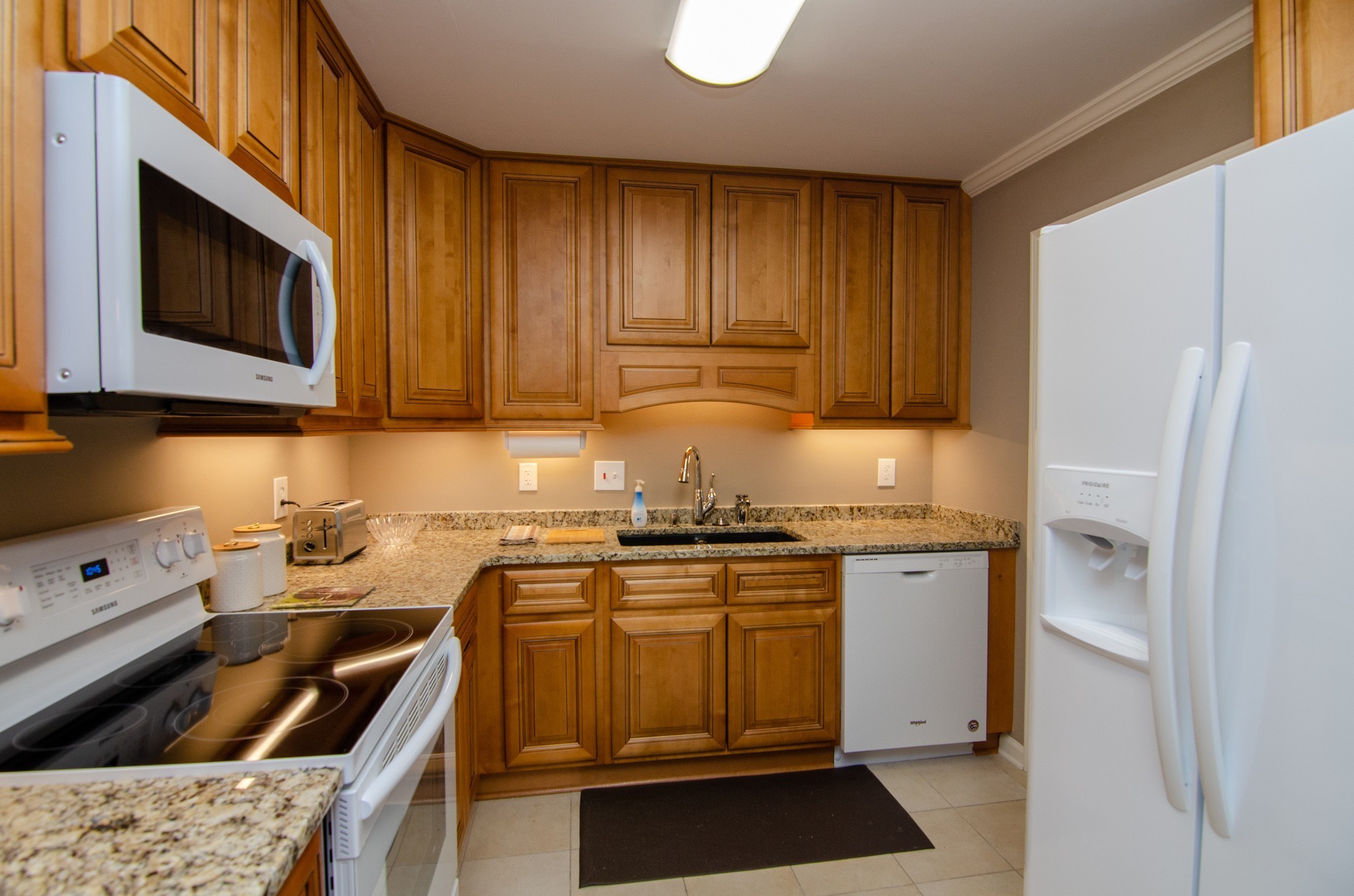 1128 General George Patton Road Nashville, TN 37221 - Photo 7 of 33 a kitchen with stainless steel appliances granite countertop a stove a sink and a microwave