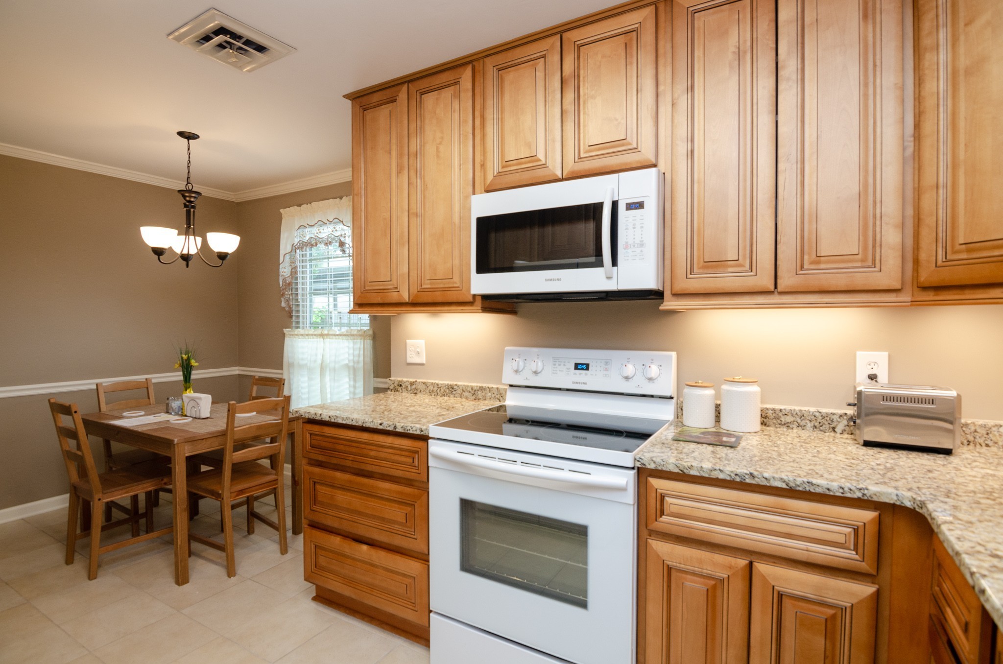 1128 General George Patton Road Nashville, TN 37221 - Photo 8 of 33 a kitchen with stainless steel appliances granite countertop a stove a sink dishwasher and a microwave oven with a dining table