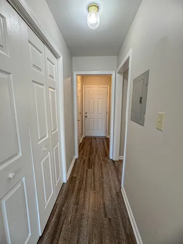 a view of a hallway with wooden floor and staircase