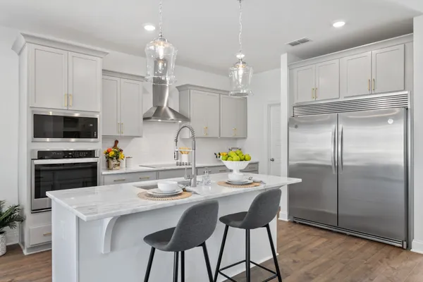 a kitchen with kitchen island a counter space a sink appliances and cabinets