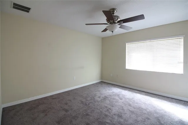 a view of an empty room with a ceiling fan