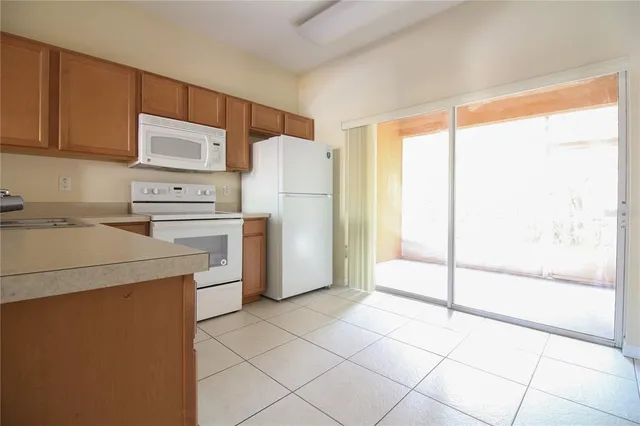 a kitchen with a refrigerator a stove top oven a counter space and a window