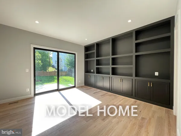 a view of an empty room with wooden floor and windows