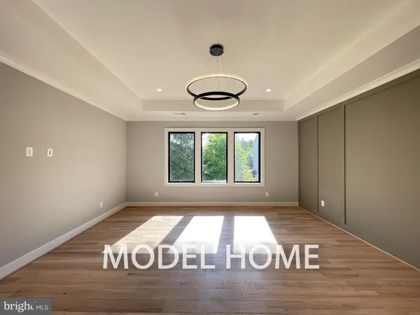 a view of an empty room with wooden floor and window