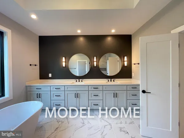 a bathroom with a sink a mirror and a bathtub next to a window