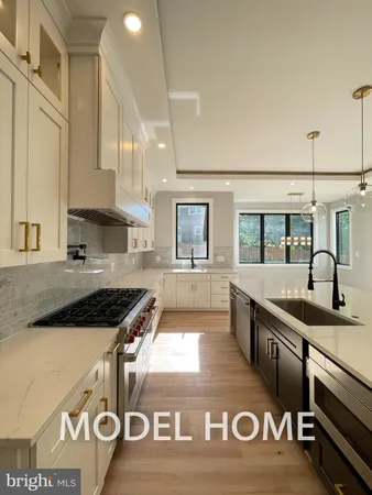 a kitchen with kitchen island granite countertop a sink stove and cabinets