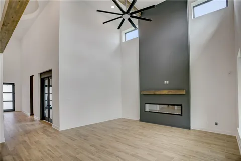a view of a room with wooden floor and a ceiling fan