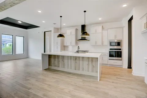 a view of a living room hardwood floor and a large window