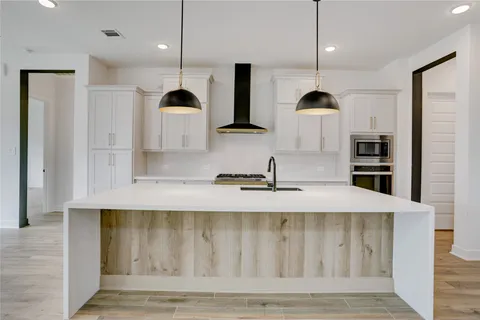 a kitchen with stainless steel appliances kitchen island wooden cabinets and a fireplace
