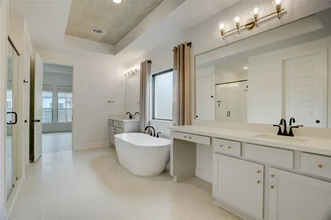 a spacious bathroom with a double vanity sink mirror and bathtub
